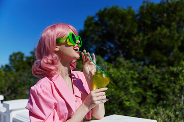 Delighted young girl in pink dress outdoors with cocktail Relaxation concept