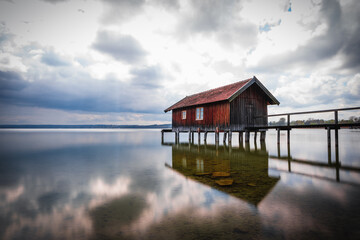Obraz premium Traditional boathouse at lake Ammersee near Munich, Bavaria, Germany at sunrise.