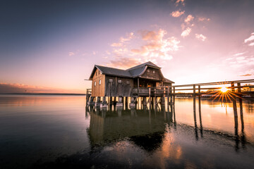 Traditional boathouse at lake Ammersee near Munich, Bavaria, Germany at sunrise.