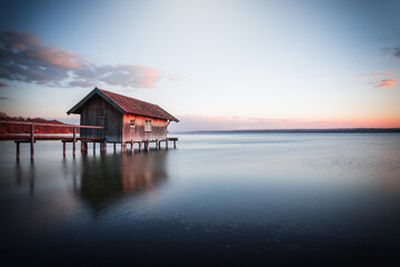 Traditional boathouse at lake Ammersee near Munich, Bavaria, Germany at sunrise. - obrazy, fototapety, plakaty