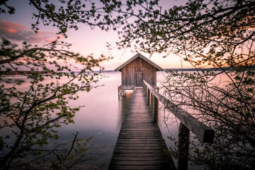 Traditional boathouse at lake Ammersee near Munich, Bavaria, Germany at sunrise.