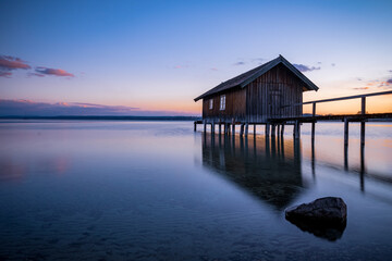 Fototapeta na wymiar Traditional boathouse at lake Ammersee near Munich, Bavaria, Germany at sunrise.