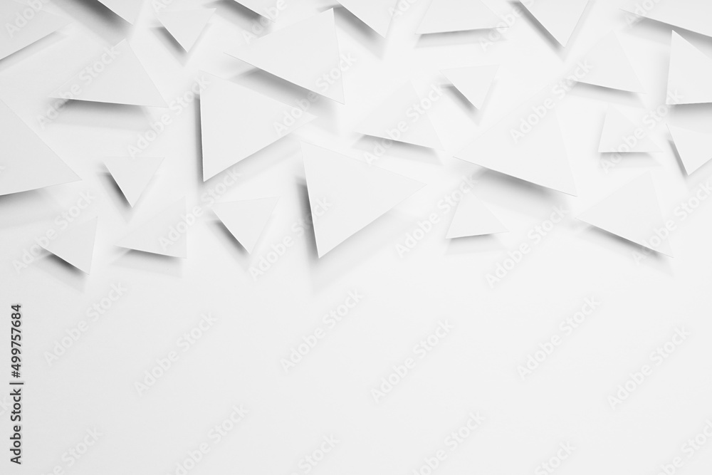 Poster white paper triangles as abstract geometric texture in bright light with soft light shadows, border,