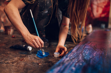 Obraz premium Woman artist hand holding colorful paintbrushes while painting