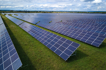 Aerial view of large sustainable electrical power plant with rows of solar photovoltaic panels for...