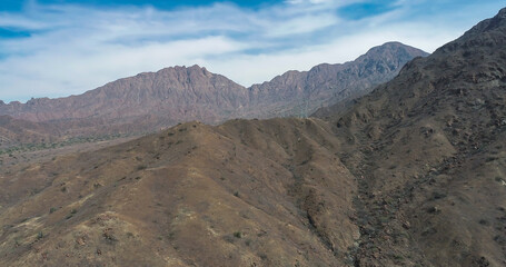 arid mountains in them you can see power towers and highways.