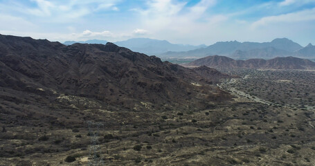 arid mountains in them you can see power towers and highways.