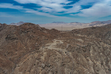 arid mountains in them you can see power towers and highways.