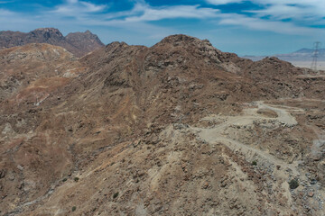 arid mountains in them you can see power towers and highways.