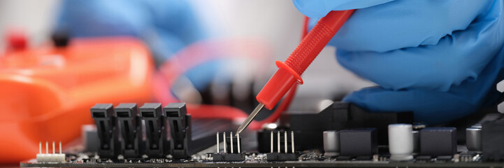 Master repairer testing motherboard with feeler gauge closeup - obrazy, fototapety, plakaty