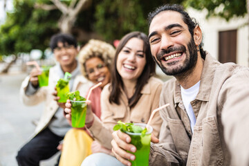 Happy multiracial friends drinking cocktails in city street - Diverse group of young people having fun together on summer vacation - Friendship and holidays concept