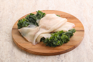 Raw squid over wooden board