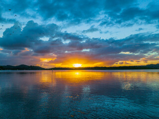 Sunrise, birds and rain clouds waterscape