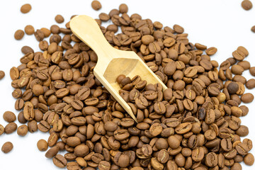 Coffee beans isolated on a white background. Full of coffee beans in a wooden spoon. Close-up.