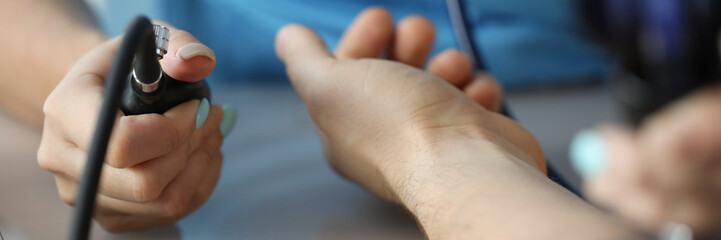 Cardiologist measuring blood pressure to patient in clinic closeup