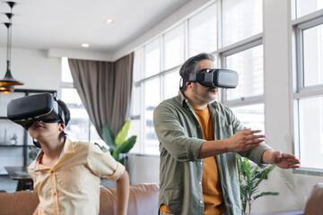 Asian father and son playing a game using VR Headsets.