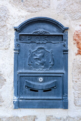 Old mailbox with lion on the coat of arms built into the wall.