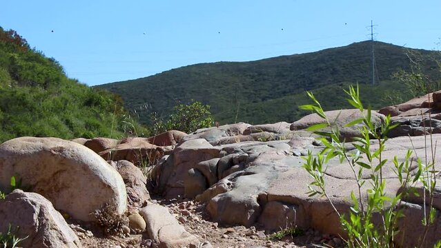 Landscape setting of smooth rock surfaces with hills in the distance.