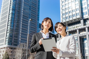 タブレットPCを持って仕事をする2人の女性