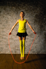 Young gymnast girl stretching and training with a skipping rope. Sport and healthy lifestyle concept. Jumping rope