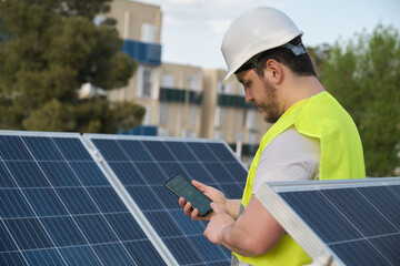 Technician using phone app for controlling photovoltaic solar power station.
