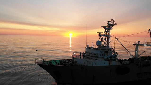 Fishing vessel at sunset in the sea. Aerial shooting from a drone.