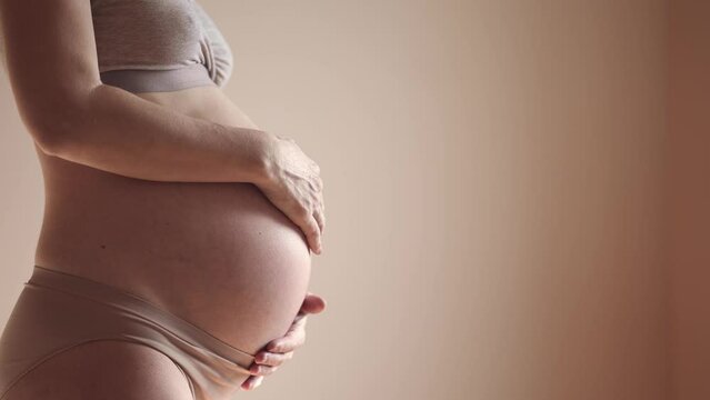 pregnant woman. health sunlight pregnancy motherhood procreation concept. close-up belly of a pregnant woman. woman waiting for a newborn baby. pregnant woman holding her belly indoors