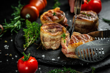 Premium Beef Steak. portion of juicy beef tenderloin steak covered bacon on dark concrete background with spices. Ketogenic diet food, top view