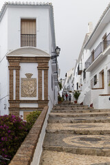Frigiliana town coat of arms on a building facade and steps