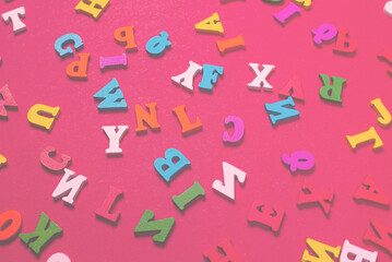 Random colorful alphabet on a red background, colorful letters.