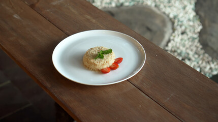 Little napoleon cake with strawberries on top standing on a white plate