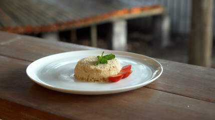 Little napoleon cake with strawberries on top standing on a white plate