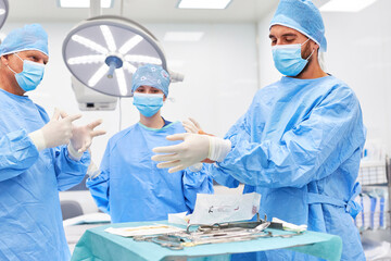 Surgeons in protective clothing and with face masks