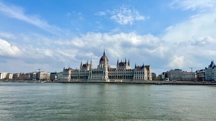 Fototapeta premium Hungarian Parliament building in Budapest night photography of bright yellow illuminated walls and dark blue sky near the Danube River. High quality 4k footage 03.04.22 Budapest, Hungary