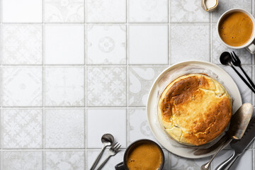Cheesecake served with coffee, cream and cutlery, on a tile background. Breakfast concept....