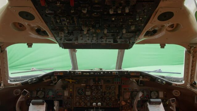 Airplane cockpit windshield with green screen backdrop.
