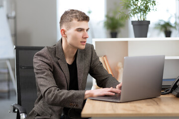 young handsome manager working in the office on a laptop