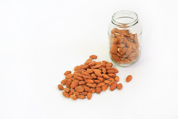 Almonds nuts and glass bottle isolated on a white background