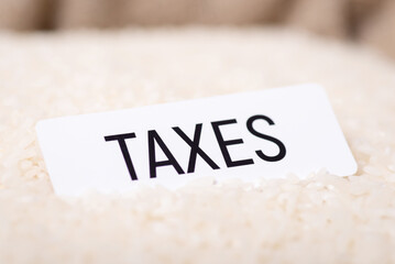 White paper with inscription Taxes on rice. High taxes on export, import of rice