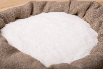 Fototapeta na wymiar White sugar sand in linen sack. Concept of sugar