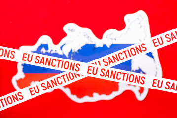 EU Sanctions inscription on white line with background of Russia flag and map. Concept of immense...