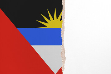 Half- ripped paper background in colors of national flag. Antigua and Barbuda