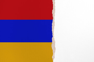 Half- ripped paper background in colors of national flag. Armenia