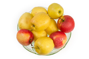 Washed yellow and red apples in glass dish, top view