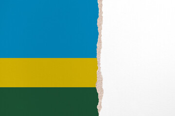 Half- ripped paper background in colors of national flag. Rwanda