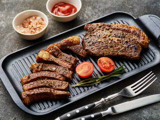 Top sirloin or cup rump steaks grilled on a black board.. Dark background. Picanha steak