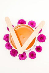 Waxing, depilation concept. Flat lay of the white cosmetic jar with sugar paste lying on white background