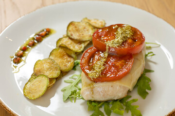 Fried turkey served with zucchini, tomato and pesto sauce