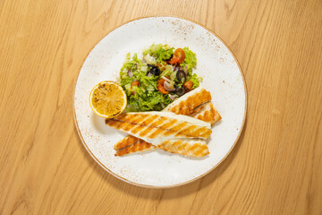 Grilled fish served with salad