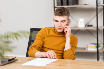 Naklejka premium young successful man working with documents in the office